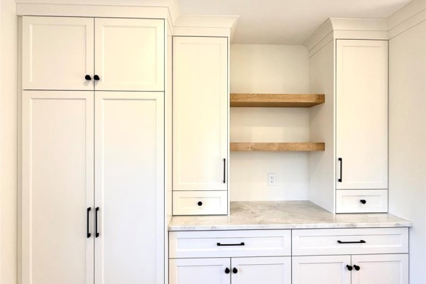 White cabinetry with black hardware, including a tall pantry and open wood shelving. - 1490 Thorburn Road, St  Philip’s