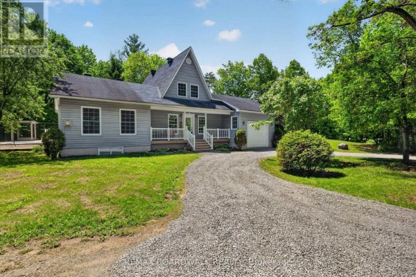 Kitchen with wood cabinets, granite countertops, double sink, and view into dining area. - 14930 Concession 10-11 Road, North Stormont