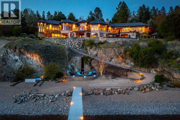 Expansive view of a luxury home on a tiered, rocky landscape with an outdoor pool. - 14966 Carrs Landing Road, Lake Country