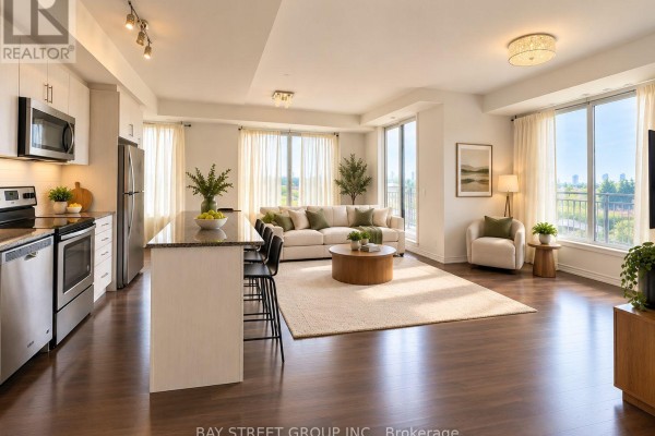 Open concept living space with kitchen island, dining area, and floor-to-ceiling windows. - 15 - 115 Long Branch Avenue, Toronto