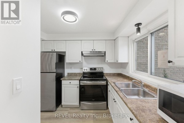 Modern kitchen with stainless steel appliances and white cabinetry - 15 - 151 Linwell Road, St  Catharines