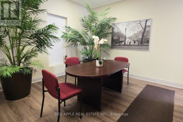Office with a table, chairs, plants, and artwork, viewed from the side. - 15 - 3045 Southcreek Road, Mississauga
