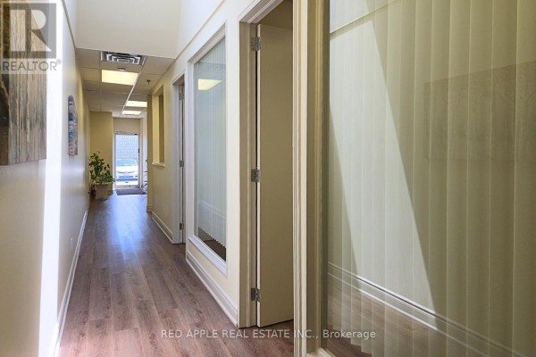 Interior hallway with offices on the right and a view to the outside. - 15 - 3045 Southcreek Road, Mississauga