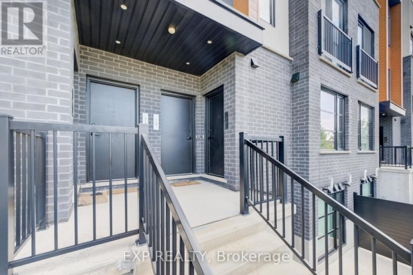 Close-up of townhouse entrances with grey brick and black doors. - 15 - 3900 Savoy Street, London South