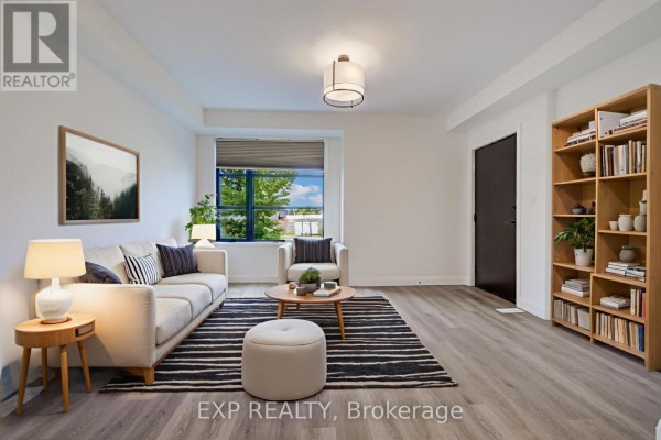 Living room furnished with a sofa, armchair, round coffee table, and bookcase. - 15 - 3900 Savoy Street, London South