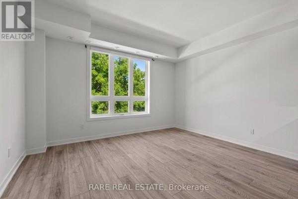 Powder room with white toilet and pedestal sink, featuring a tall window with backyard view. - 15 - 4045 Hickory Drive, Mississauga