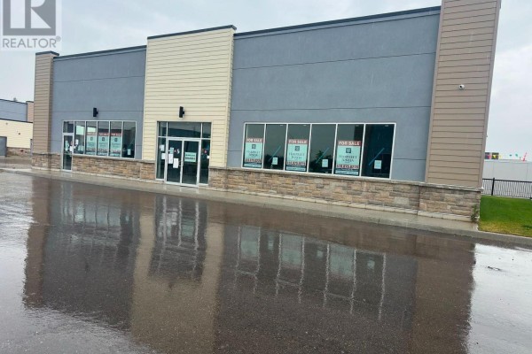 Front view of a commercial property with reflective wet pavement in front. - 15-16 - 200 Montclair Drive, Woodstock