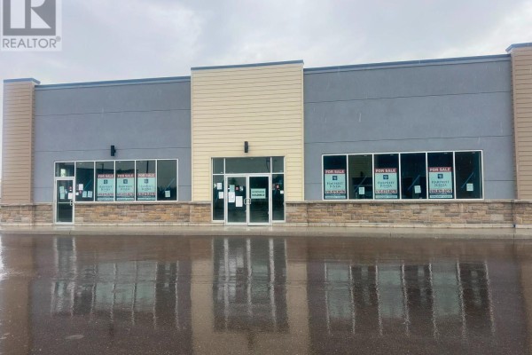 Wide shot of a commercial building entrance and windows with FOR SALE signs. - 15-16 - 200 Montclair Drive, Woodstock