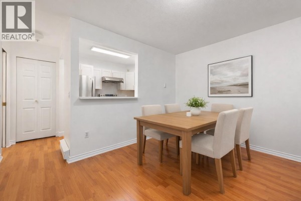 Dining area with a table set for six, overlooking the kitchen. - 15 3428 Adanac Street, Vancouver