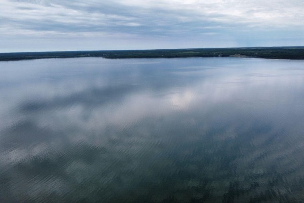 Aerial view of a calm lake reflecting the cloudy sky. - #15 62064 Range Road 133, Rural Smoky Lake County