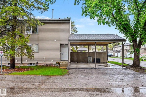 Exterior view of townhouse with covered carport and beige siding. - 15 Akinsdale Gd, St  Albert
