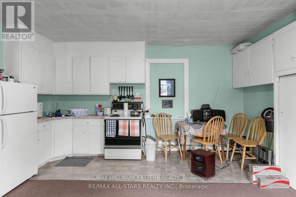 Open kitchen area with white cabinets, appliances, and dining table. - 15 Albert Street, Selwyn