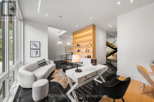 Spacious primary bedroom with light wood floors, king-sized bed, seating area, and large window. - 15 Aldershot Crescent, Toronto