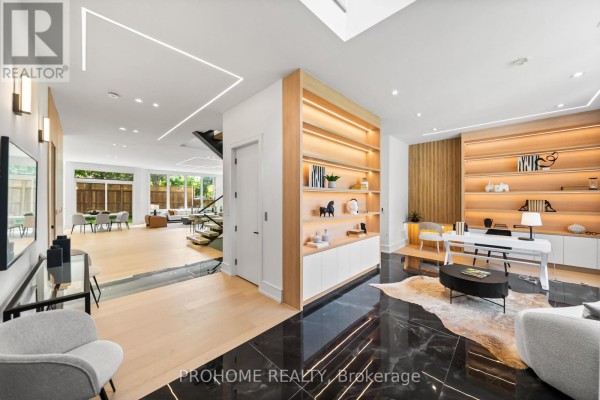 Contemporary dining room with a long table, upholstered chairs, fireplace, and modern lighting fixture. - 15 Aldershot Crescent, Toronto