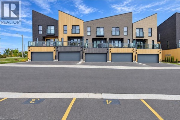 Row of modern townhouses with garages numbered 7, 11, 13, 15, 19, 21 under a blue sky. - 15 Benninger Drive, Kitchener