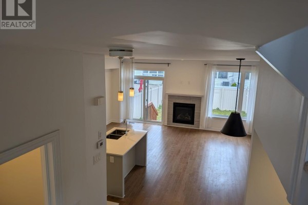 View of the living room and kitchen from above, showing hardwood floors and island. - 15 Brixton Way, Ottawa
