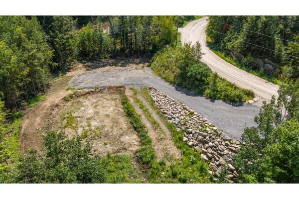 Aerial view of cleared land parcel with gravel access road and wooded surroundings. - 15 Ch. Du Cristal, La Peche