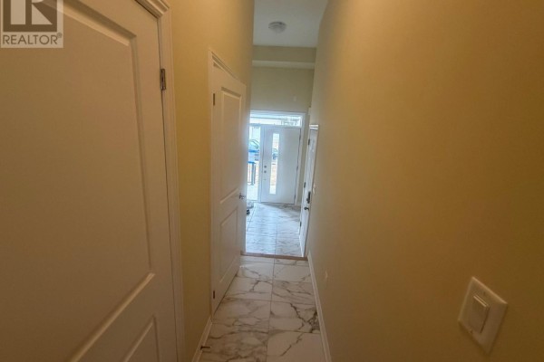 Interior hallway with cream-colored walls, tiled floor, and doors leading to rooms. - 15 Chapman Road, Brant