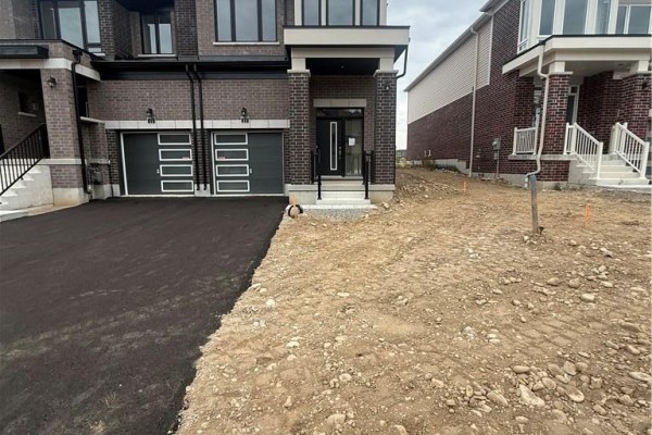 Exterior view showing asphalt driveway, townhouse front, and unfinished landscaping. - 15 Chapman Road, Paris