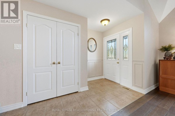 Foyer with tiled floor, double white doors, and a decorative glass front door with matching sidelights. - 15 Costigan Court, Halton Hills