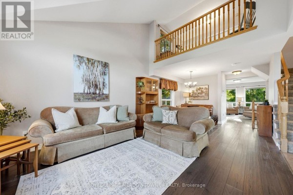 Living room with view of a loft area, staircase, dining area, and furniture grouping with two sofas. - 15 Costigan Court, Halton Hills