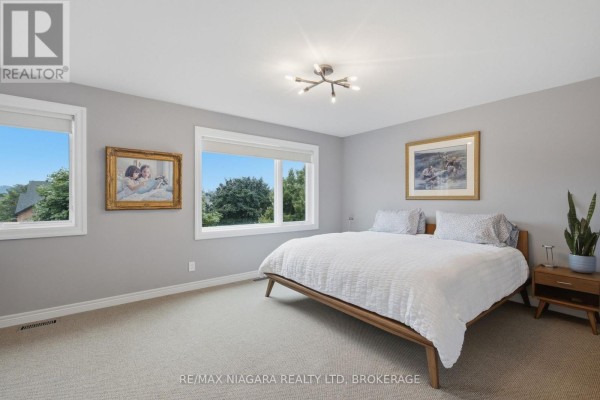 Foyer with white shoe cabinet, grey rug, and glass panel front door. - 15 Cozocar Crescent, St  Catharines