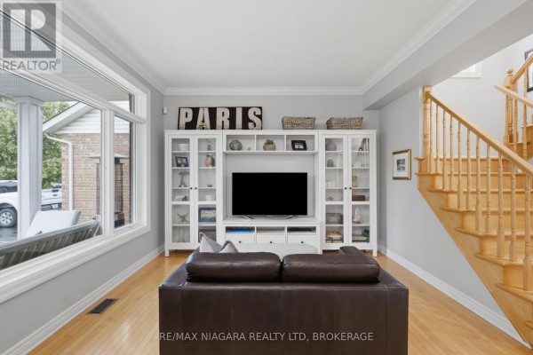 Living room with entertainment center and sofa - 15 Cozocar Crescent St Catharines