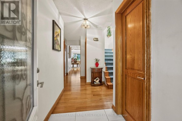 Interior view of a sunroom with brick walls and a large arched window. - 15 Craiglee Drive, Toronto