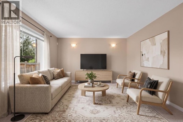Living room with a sofa, two armchairs, coffee table, television, and a large window with curtains. - 15 Cranfield Manor Se, Calgary