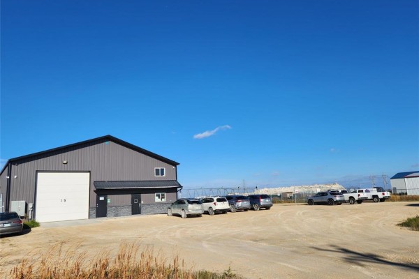 Wide shot of the property with multiple parked vehicles and a gravel lot - 15 Dielmann Drive, Headingley