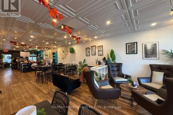 Interior view of seating arrangements and wall decor with tin tile ceiling. - 15 Dunlop Street W, Barrie
