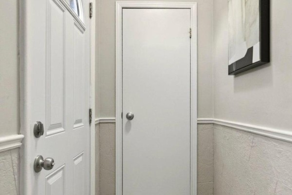 Interior hallway with two white doors, one with glass panels, and textured walls. - 15 East 27th Street, Hamilton