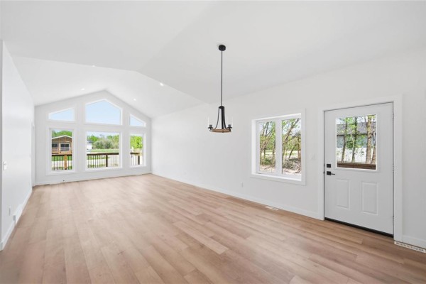 Interior living room with vaulted ceiling, large windows overlooking a deck, and a door. - 15 Everwood Crescent, Matlock
