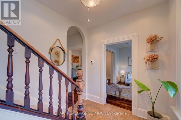 Hallway with wooden staircase, arched doorway, and mirror - 15 Gilholm Avenue Cambridge