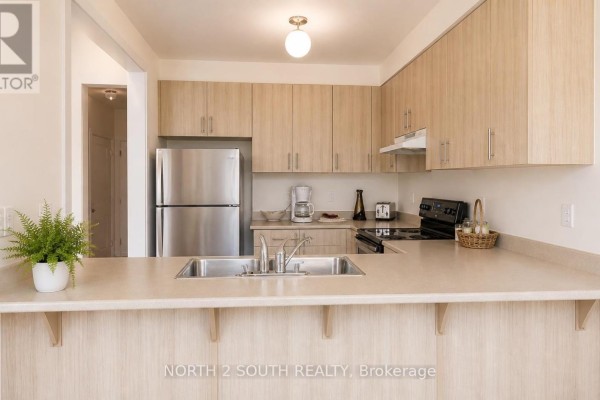 U-shaped kitchen with light wood cabinets, stainless steel sink, and light laminate countertops. - 15 Gower Drive, Aurora
