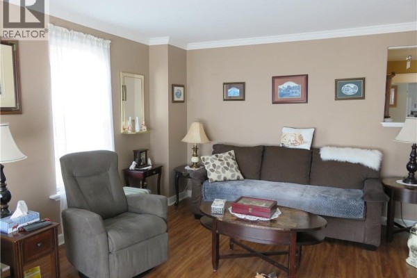 Kitchen showing a white refrigerator, white cabinets, and dark green wainscoting on the lower walls. - 15 Green Street, Saint John