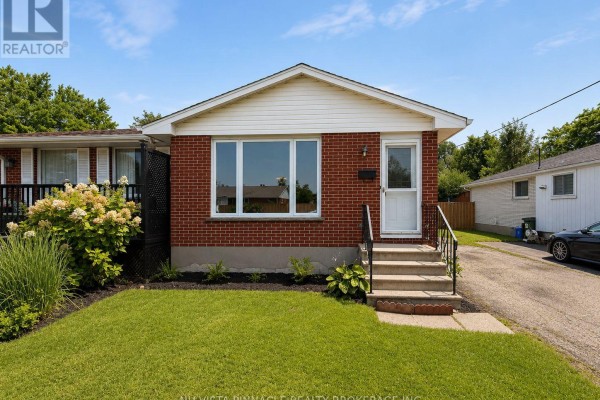 Front view of a red brick bungalow with a white-trimmed gable roof and large front window. - 15 Gregory Place, St  Thomas