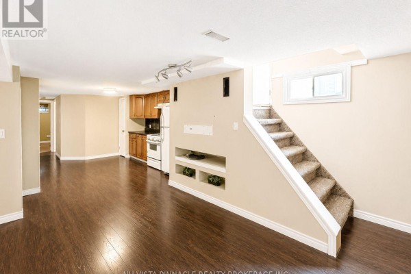 Basement living area with kitchenette, dark wood floors, and carpeted stairs - 15 Gregory Place St  Thomas