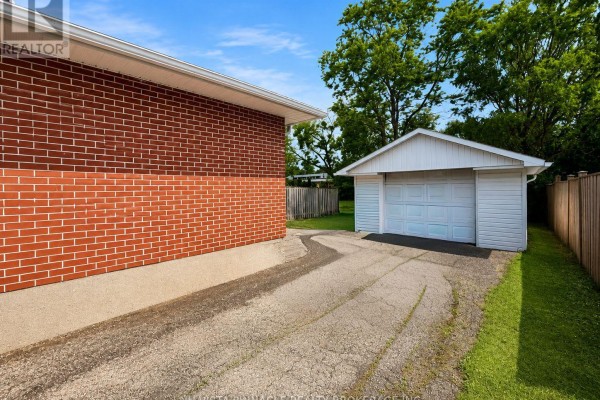 Side view of a brick bungalow with a detached garage and a paved driveway. - 15 Gregory Place, St  Thomas