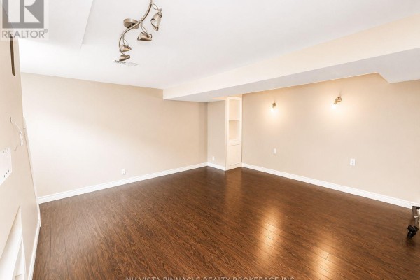 Empty living room with hardwood floors, built-in shelves and track lighting - 15 Gregory Place St Thomas