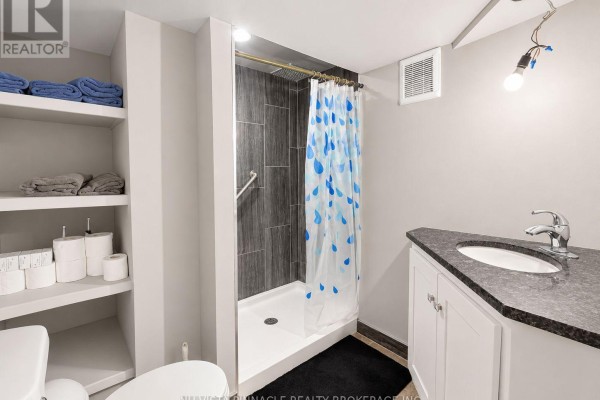 Modern bathroom with shower, vanity, toilet, and shelving - 15 Gregory Place St Thomas