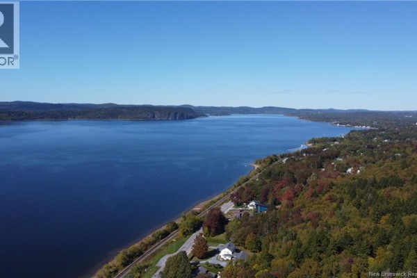 Expansive aerial view of a large blue lake with distant tree-lined shores and a curve of shoreline in the foreground. - 15 Hazen Avenue, Rothesay
