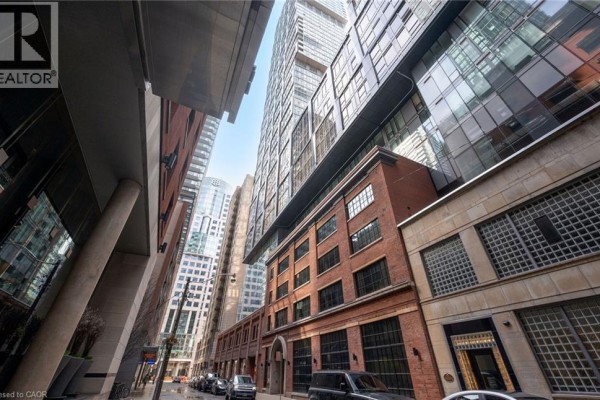 Street view of brick and glass apartment buildings with cars parked on the street. - 15 Mercer Street Unit# 620, Toronto