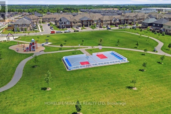 Aerial view of a park with a playground, walking paths, and a basketball court. - 15 Moriarity Drive, Brant