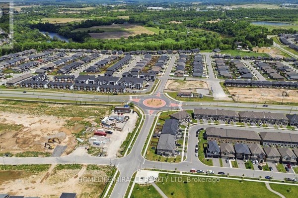Aerial overview of a large suburban development with homes and a park. - 15 Moriarity Drive, Brant