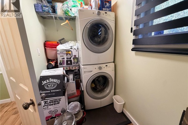 Laundry area with stacked white washer and dryer and assorted storage boxes. - 15 Murray Lake Crescent, Murray Lake