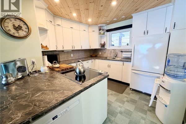 Kitchen with white cabinets, granite countertops, electric stove, and water cooler. - 15 Murray Lake Crescent, Murray Lake