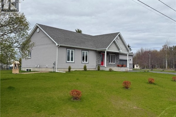 Bedroom with two beds, orange and yellow bedding, and white bi-fold closet doors. - 15 Rue Girouard, Saumarez