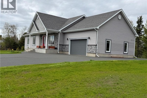 Bathroom with a corner glass shower stall, vanity with black countertop, and tiled flooring. - 15 Rue Girouard, Saumarez