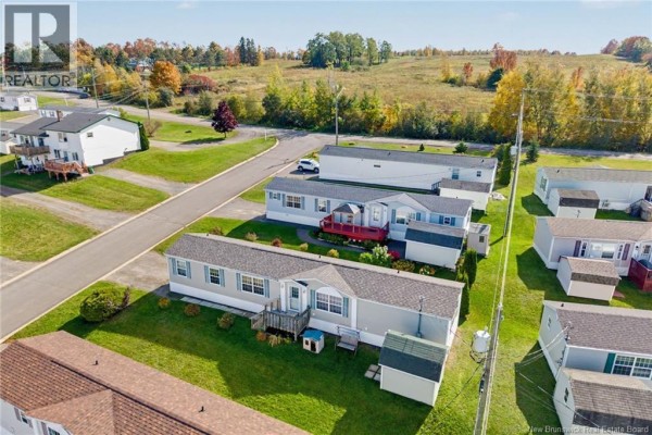 Aerial view showing the manufactured home at 15 Senator Drive and surrounding homes and landscape. - 15 Senator Drive, Fredericton